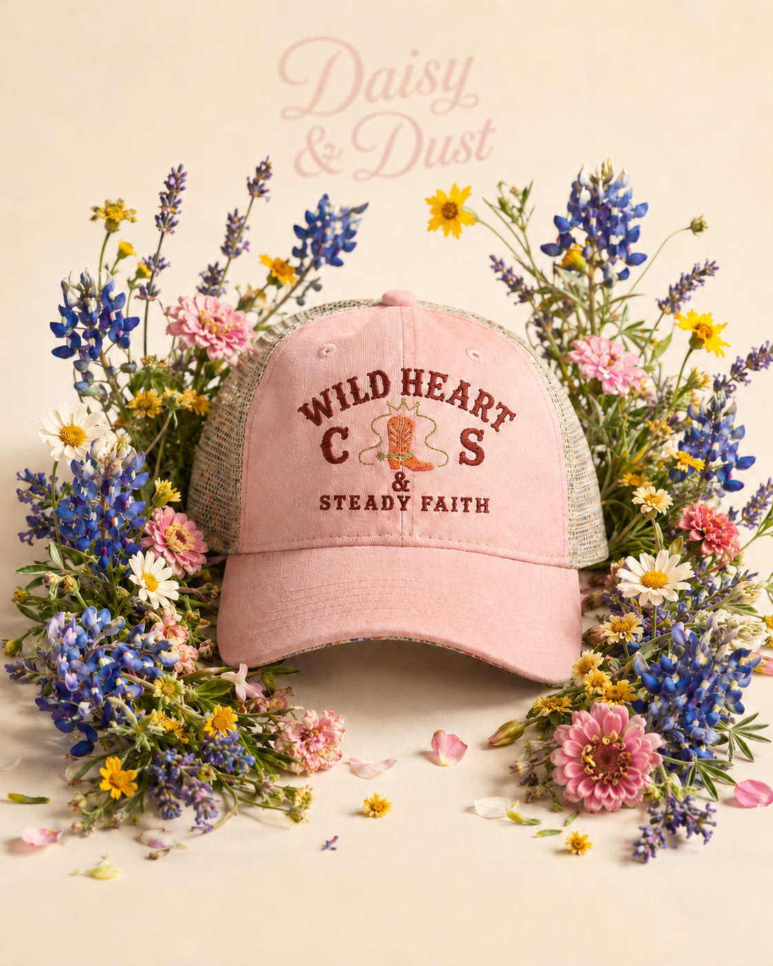 Daisy & Dust women's dusty pink ponytail cap surrounded by wildflowers